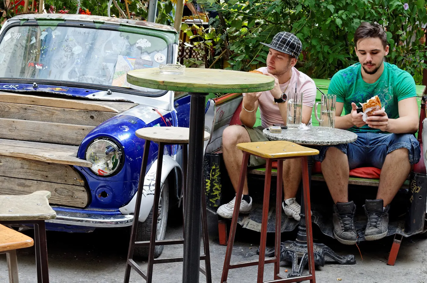 Mismatched furniture and an old car used as seating in the Szimpla Kert ruin bar courtyard, Budapest