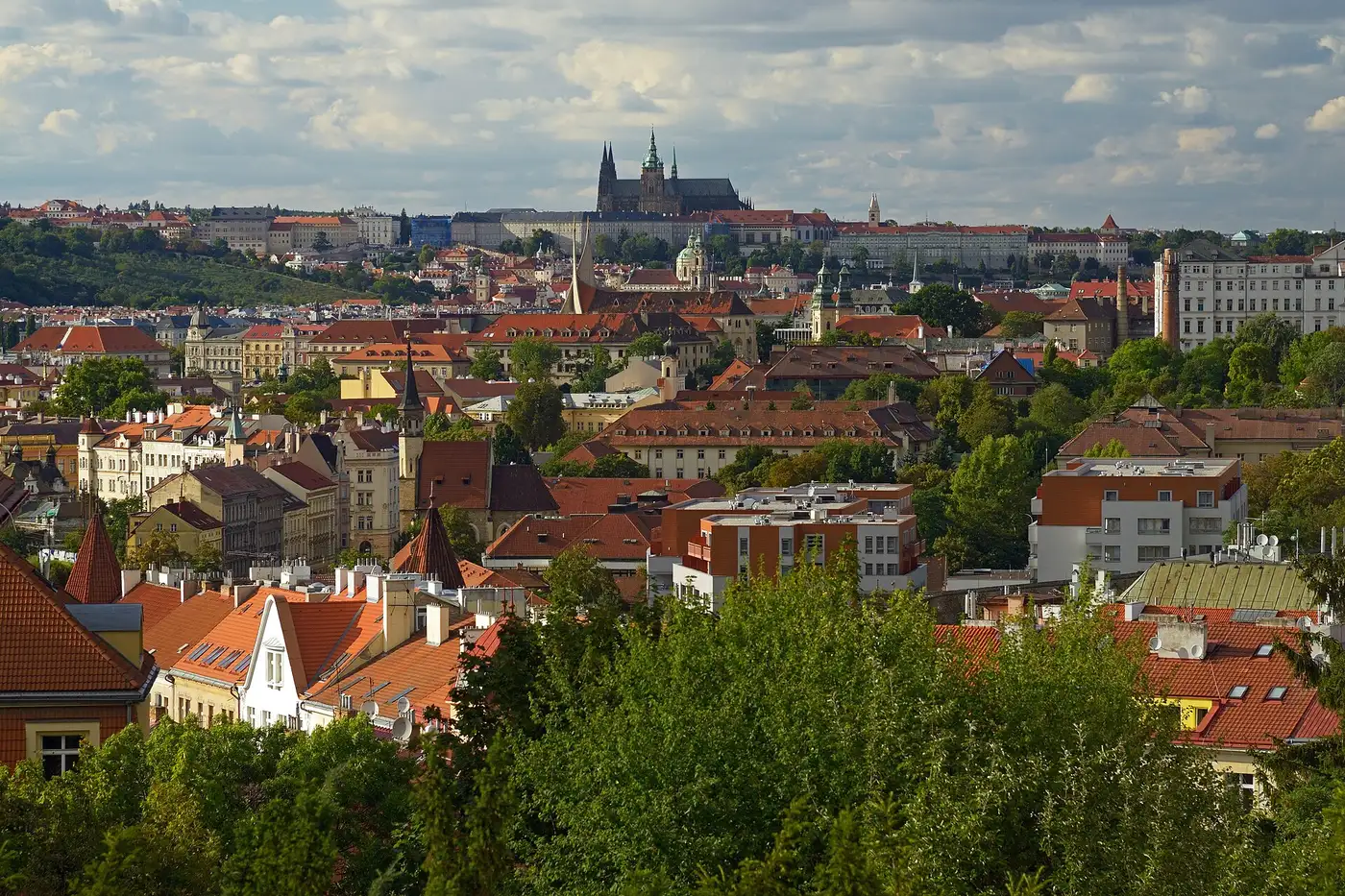 Prague Castle and St Vitus Cathedral rising above the red roofs of Malá Strana, seen from Vyšehrad