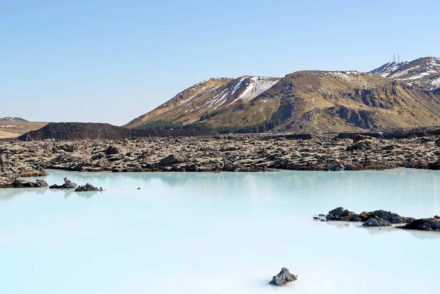 Milky blue water of the Blue Lagoon with lava field and Mount Thorbjorn