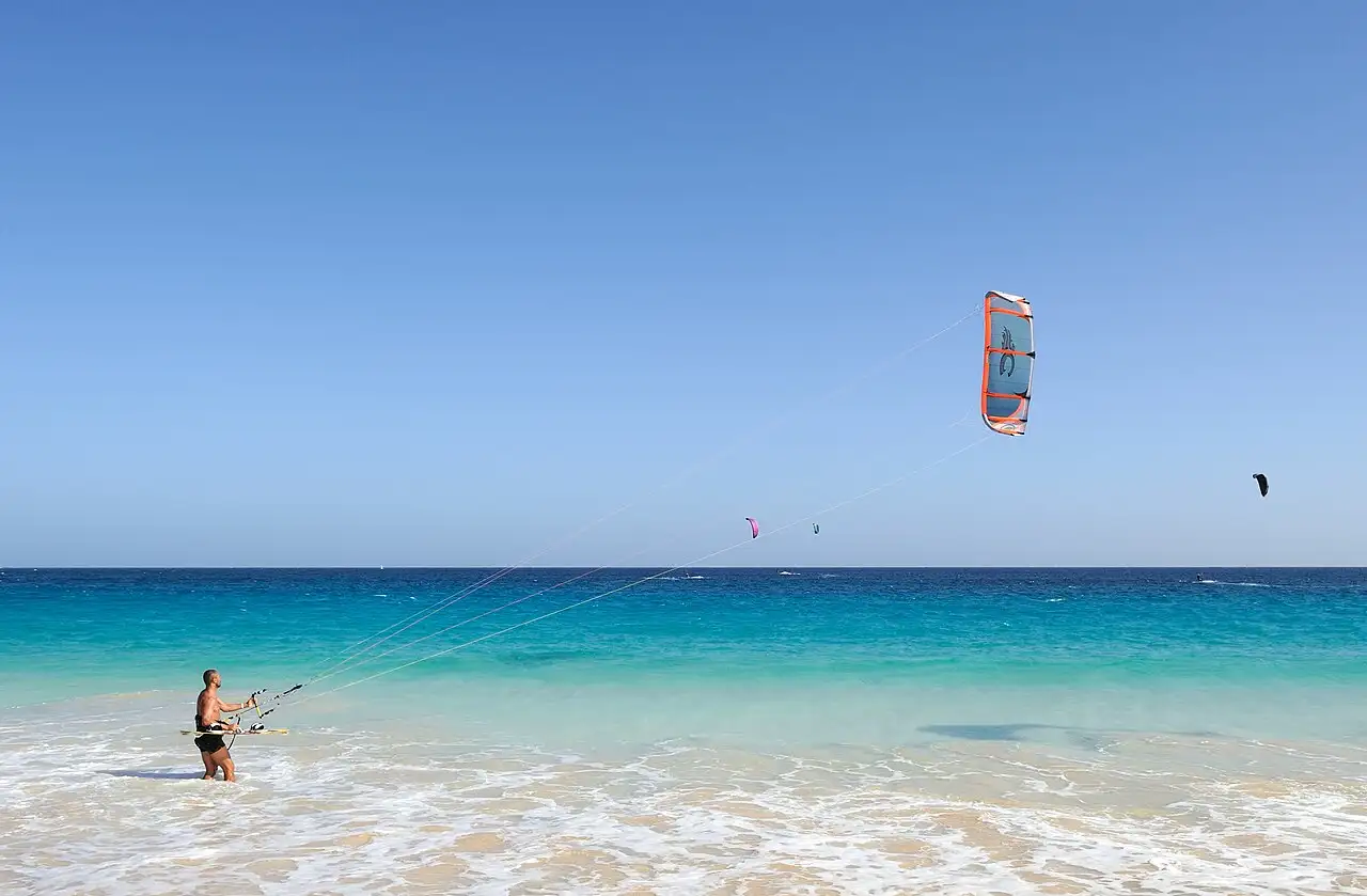 Kitesurfer launching a kite from the turquoise shallows off Sal, Cape Verde