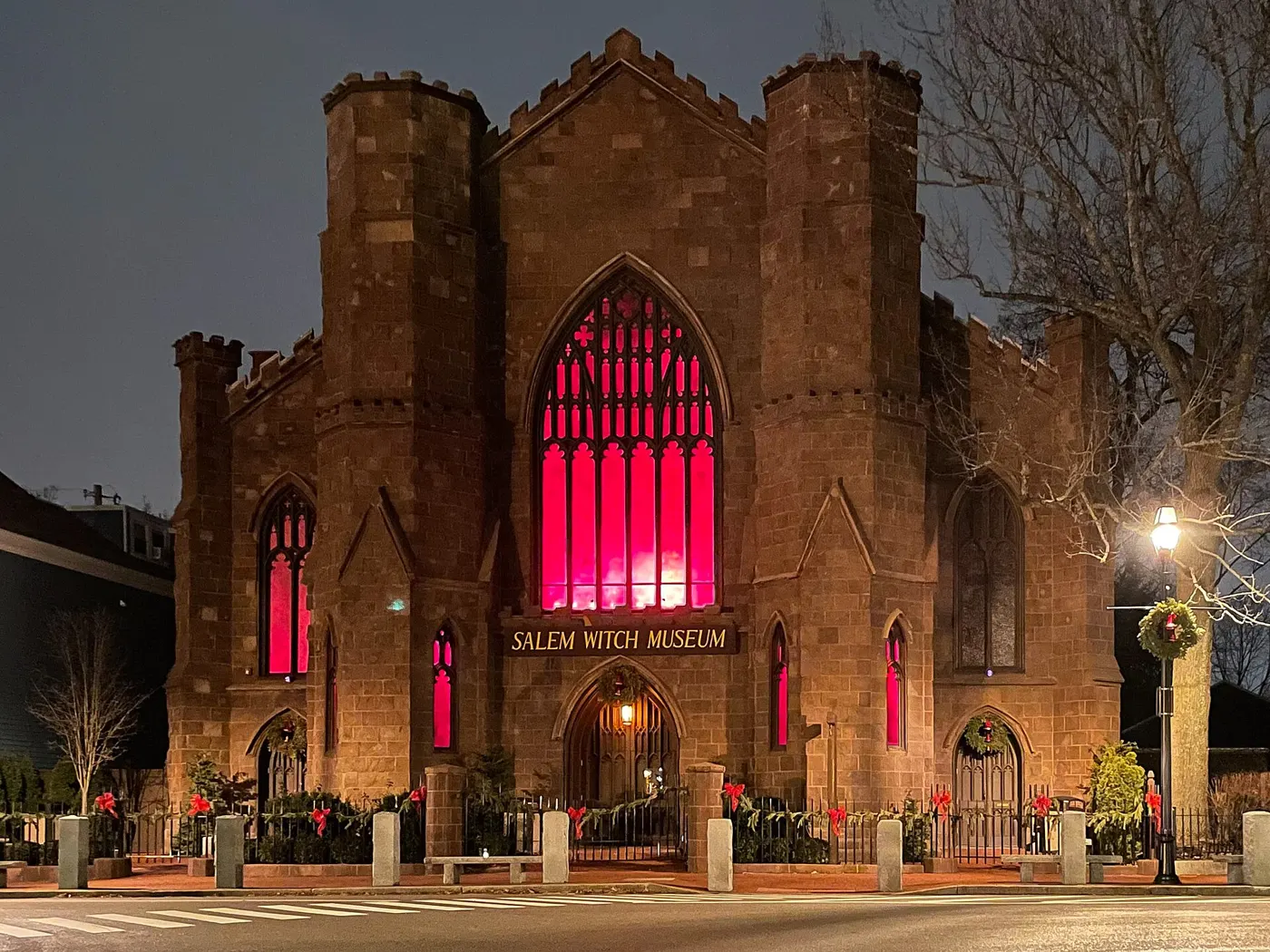 The Salem Witch Museum lit up at night, with red glowing windows