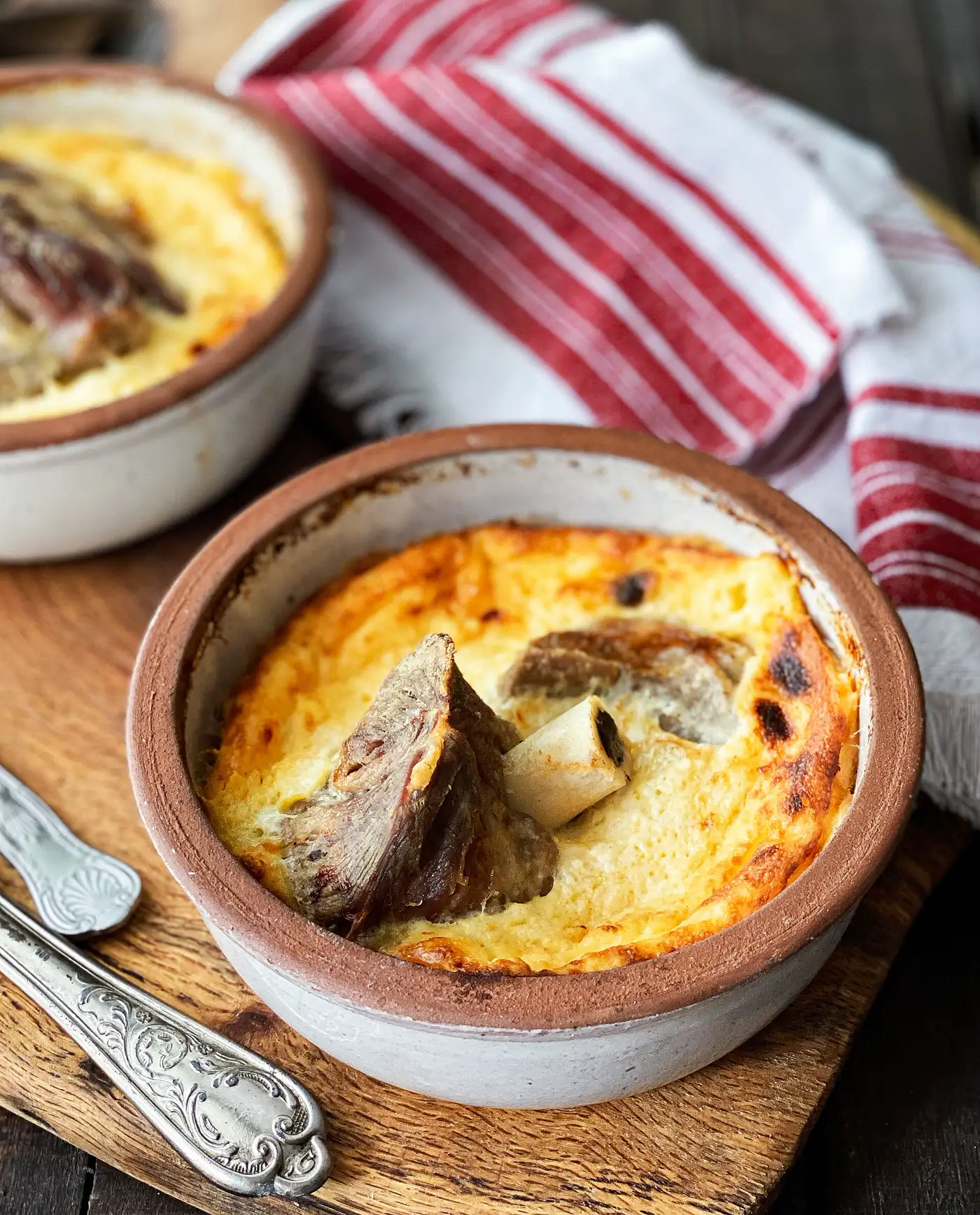 Tavë kosi, the Albanian baked lamb dish under a golden yogurt topping, served in a clay dish