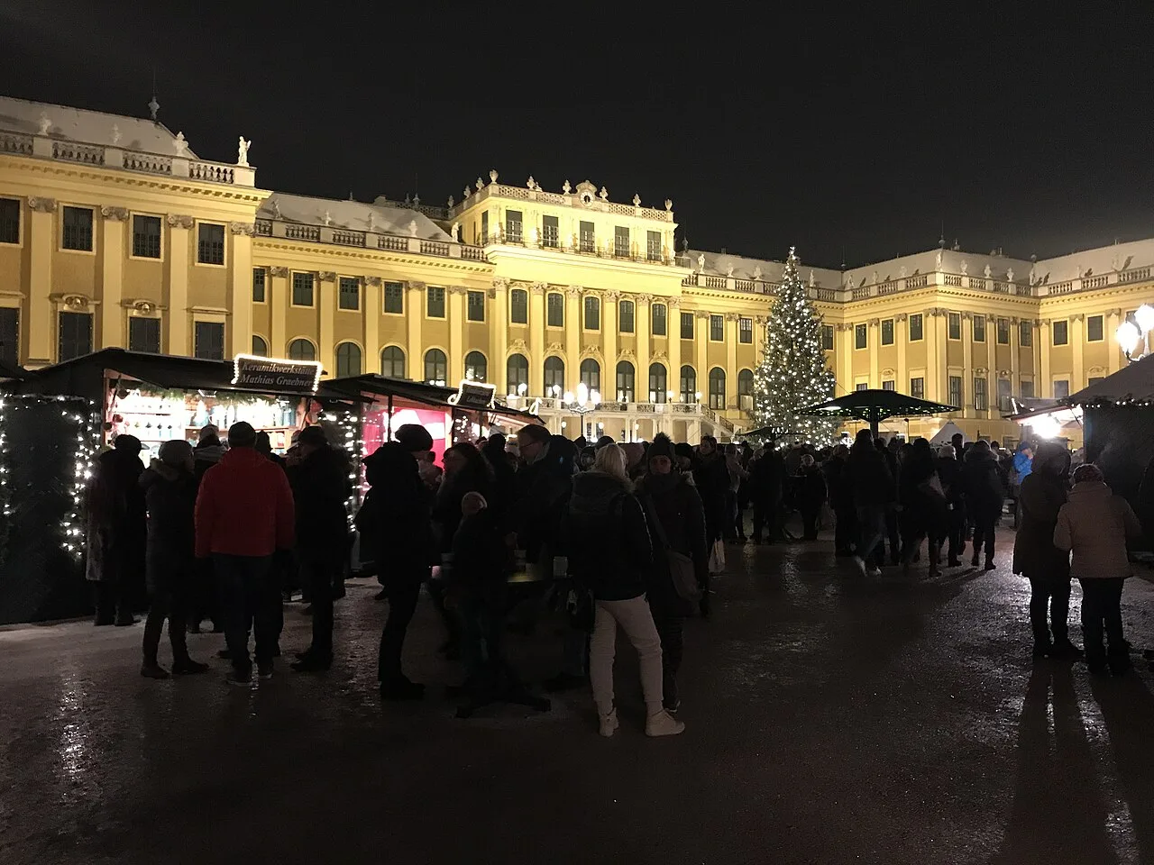 Christmas market stalls and a lit tree in front of Schönbrunn Palace, Vienna